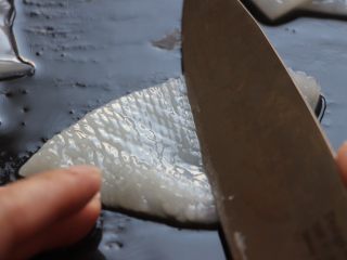 4、酱爆鲜鱿,将鱿鱼筒对半剪开,切成大小差不多的块状。刀倾斜着在鱿鱼筒内壁表面划刀,间隔匀均,(我切的差不多间隔2mm,内壁切不容易切断),然后交叉再划一遍。