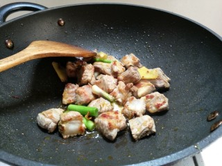 6、糖醋排骨,放入姜片，蒜茎慢慢煸炒