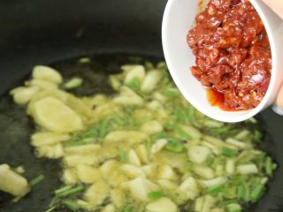 13、水煮肉片,放入豆瓣酱，超出红油后，放一碗水，熬煮充分。约10分钟。