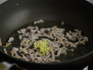 2、干煸菜花,炒至肉丝变色后加入姜末，翻炒均匀