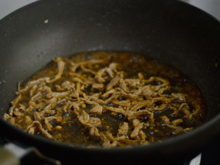 3、干煸菜花,调入酱油和料酒，翻炒上色