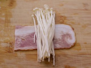 4、金针菇培根卷,取一半，放些金针菇在上面。