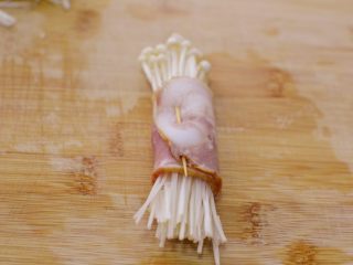 5、金针菇培根卷,卷好，用牙签固定。