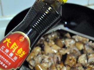 5、黄豆烧猪蹄,倒入2大勺的红烧酱油，加入1大勺料酒，翻炒1分钟。