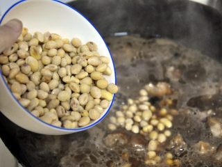 7、黄豆烧猪蹄,大火烧开后倒入黄豆。