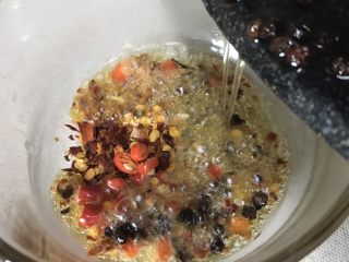 6、馋嘴川味口水鸡,把热好的花椒油迅速倒入碗里,会有滋啦滋啦的声音,辣椒也散发出香味