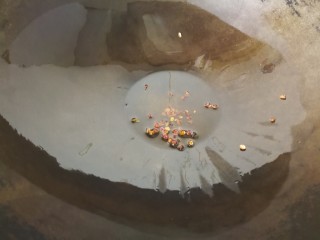 8、麻辣香锅,放入花椒粒小火煸炒，炒至花椒变黑以后，捞出花椒丢掉，留花椒油在锅里。
