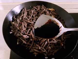 9、冷吃牛肉,倒入适量红酱油（也可以用老抽），继续翻炒。