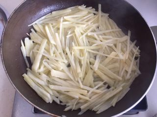 8、土豆丝饼,然后放入土豆丝，用铲子交叉铺好。