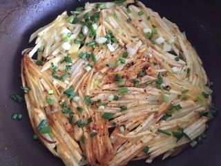 12、土豆丝饼,然后再撒些辣椒面，葱花也撒上。