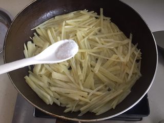 9、土豆丝饼,把少许盐撒在土豆饼表面。（这里勺子里的盐是包括底下一层的）