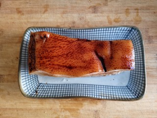 5、梅菜扣肉,趁热在皮上涂一层老抽酱油至表面干透。