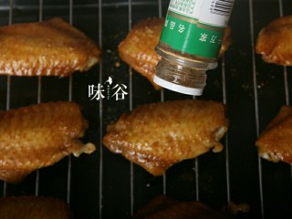 10、烤鸡翅,然后拖出来,洒上一层孜然粉。