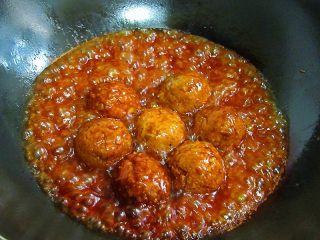 9、(私家秘制版)红烧鹌鹑蛋狮子头,将锅中的油盛出后,放入丸子,加入高汤或水、老抽、姜、葱,烧沸后改微火烧1小时以上,熟透后把丸子捞出装盘待用