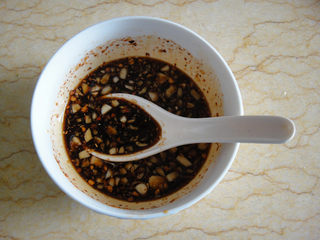 5、口水黄瓜,碗中加入3调羹鲜酱油和2调羹甜醋把蒜泥和辣椒面加入拌匀