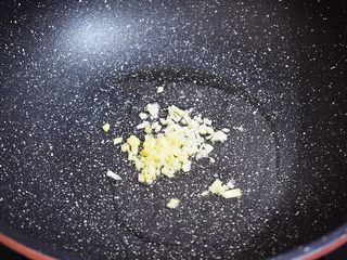 3、番茄金针菇肥牛,锅中倒入适量的食用油烧热，再放入蒜末和姜末炒出香味