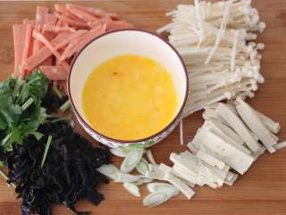 2、酸辣暖胃汤,豆腐切细丝、木耳切细丝、火腿切细丝、鸡蛋打散、香菜切段。