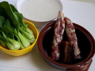 1、煲仔饭,1.备好材料:泡好的大米、清洗干净的菜心、香肠和酱肉。