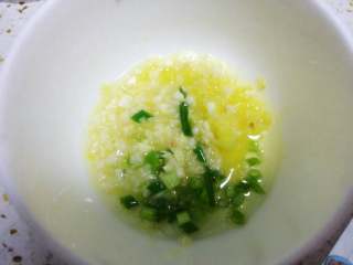 5、白切鸡,碗里放入葱姜蒜,锅里倒入适量色拉油烧热,再倒入葱姜蒜碗里。也可以直接加入一勺芝麻油。