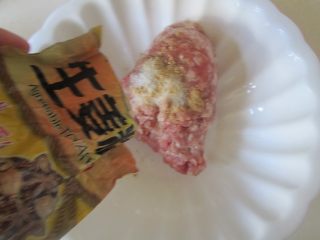 6、焦香土豆丸,肉末中加入适量的盐、料酒、胡椒粉和姜粉顺着一个方向搅拌上劲;
