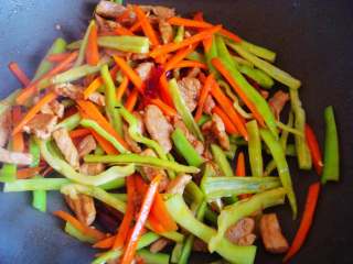 11、青椒炒肉丁,倒入青椒，翻炒断生加入盐，即可出锅。