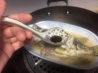 6、清蒸鳜鱼,关火焖一分钟左右,揭开锅盖,淋上蒸鱼豉油。