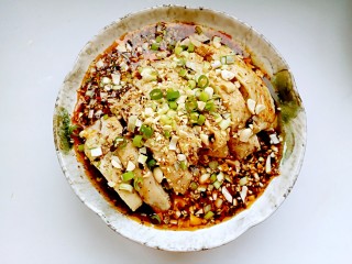 11、口水鸡,淋上勾兑好的料汁，撒上花生碎、香葱、蒜末、白芝麻即可享用。