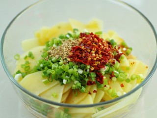 10、凉拌香辣土豆片,将葱花、白芝麻和辣椒面放在最上面