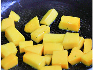 7、芒香双花,炒锅内放入少许橄榄油，烧热后下芒果丁，翻炒至芒果丁变色