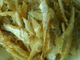 2、手撕咸鱼,把鱼尾切掉，用手把咸鱼从尾部椎骨处往上撕，撕出大片后再撕成自己喜欢大小的条条