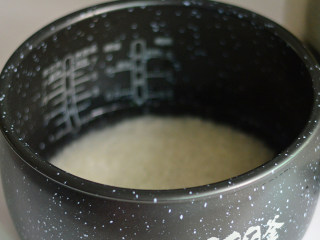 2、土豆排骨焖饭,先将大米淘洗干净,放入电饭锅内胆,浸泡约20分钟