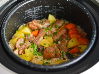 11、土豆排骨焖饭,程序结束后先不要打开盖子,继续闷10分钟。之后再打开,淋上香油,撒上一些葱花即可