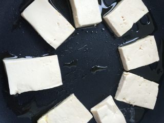 6、香煎豆腐,锅内放油，烧至9成热，把豆腐整齐摆放在锅内