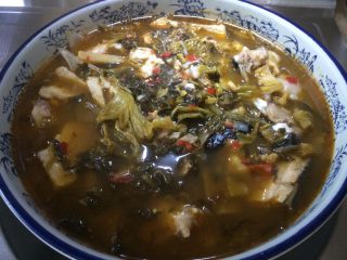 9、酸菜鱼,把烧好的鱼头类倒入盘中。