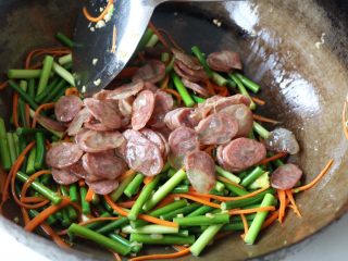 11、蒜苔炒腊肠,倒入腊肠翻炒；