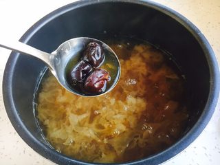 12、冰糖银耳雪梨粥,待放气后捞出大枣,用小勺挤压大枣,除去大枣皮和大枣核,枣肉留在锅里。