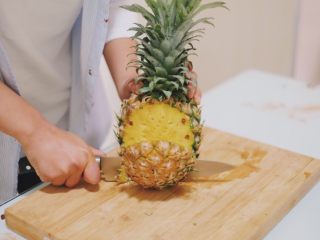 1、清甜可口的菠萝饭~,先处理菠萝,从侧面切开
