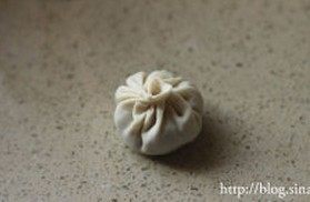 8、灌汤小笼包,包入适量的肉馅，用手沿同一方向打褶，将包子包好