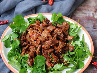 12、孜然羊肉,出锅前加入辣椒碎,炒好的羊肉盛入铺满香菜的盘中就可以上桌了