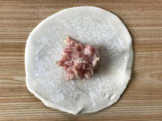 5、四喜蒸饺,取一张饺子皮，中间放上适量肉馅；