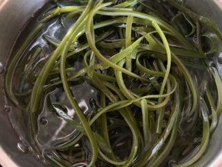 6、凉拌海带丝,起锅烧水,水开后放入浸泡过的海带丝,盖上锅盖煮约3分钟