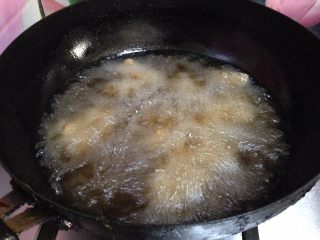 11、麻辣羊肉,锅内加油烧至4、5成热，分次放入羊肉丁炸制