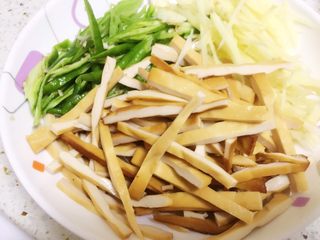 3、香辣豆腐干炒肉丝,豆腐干切细条,青辣椒切斜丝,嫩姜切丝,大蒜切片备用。(嫩姜很香脆,如果不好买,可用老姜姜丝代替。)