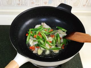 7、干锅花菜,加入姜片、蒜和辣椒爆香。