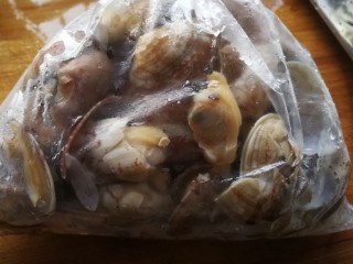 4、吃了不怕长胖的美食___酱爆花蛤,洗净后，锅内烧开水放入滤干水的花蛤。开口即可捞出。因为有强迫症怕有残留泥沙，所以我会再次冲洗干净。滤干水份。为了节约时间，经常会冷冻保存，吃时解冻可以省去很多时间。比如今天这就是冷冻过的。解冻的花蛤袋子角的一边剪角朝下放入漏篮可以滤出袋子里多余的水。