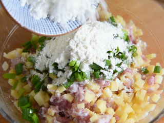 6、土豆饼很多人都喜欢吃, 这样做别提有多香, 根本停不下来,碗中倒入1g盐、30g葱花、20g面粉、20g淀粉、3g十三香，拌匀