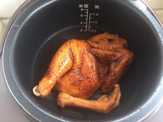 11、电饭煲烤鸡,放入电饭煲，所有料汁倒入，再加入半小碗水（吃饭的小碗）。液体只需底部一点点即可。然后盖上锅盖，按标准煮饭键开煮
