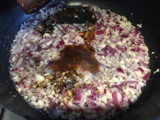 4、蒜香烤茄子,接着倒入洋葱丁继续翻炒，关火，倒入蚝油、生抽，适量老抽，加入适量盐，翻炒均匀