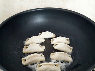 10、早餐锅贴,煎锅中放入2汤匙玉米油,摆放锅贴,中小火烙至底部金黄色色。