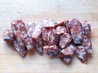 2、电饭煲+腊肠杂蔬焖饭,将腊肠洗净，剥去外衣，切成斜刀片备用。